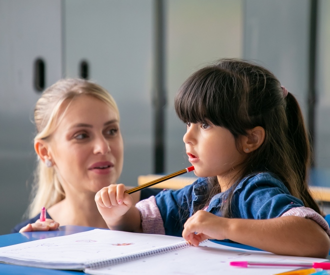 cheerful-young-school-teacher-helping-little-sk_i.jpg